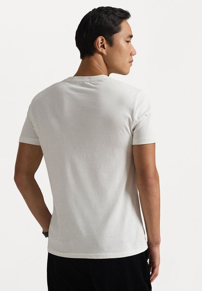 Valge puuvillane T-särk lühikeste varrukatega, ümar kaelus ja sile tekstuur. Lihtne disain ilma nähtavate mustrite või aktsentideta.