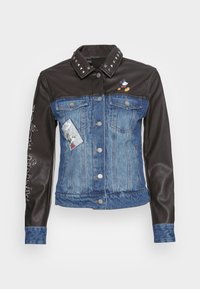Giacca in denim e finta pelle con corpo blu, spalle nere, colletto borchiato, patch e dettagli grafici sulle maniche. Cinque bottoni.