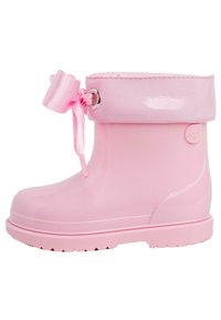 Bottes de pluie en caoutchouc rose avec une finition brillante, revers ajustable avec un détail en ruban satiné et semelle texturée pour une adhérence optimale.