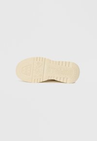 Buffalo plattform sneaker såle, kremgummi materiale, strukturert grep mønster, preget merkevare, med stjernemotiver og rillede kanter.