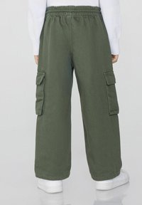 Khaki kalhoty ve tmavě zelené barvě, vyrobené z odolné tkaniny, s elastickým pasem, širokými nohavicemi a dvěma bočními kapsami.