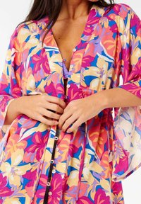 Blomster kimono i levende pink, bl�å og gule nuancer. Letvægtsstof, løs pasform, med knapper og brede ærmer. Blomster mønster detaljer.