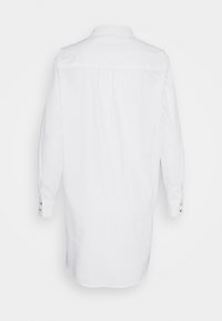 Abito camicia bianco lungo con maniche lunghe e bottoni ai polsini, mostrato dal retro su sfondo neutro.