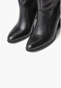 Czarne skórzane botki za kostkę z szpiczastymi noskami, z przeszywanym wzorem, obcasem na słupku i gładką fakturą. Brak widocznych metalowych elementów lub ozdób.