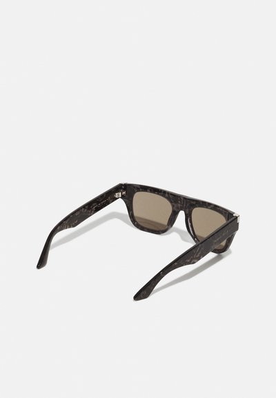 Solski briller med en mørk mønstret plastisk ramme, brune tonede linser og slanke arme med en metallisk accent nær hængslet.