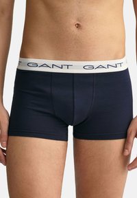 Boxer briefs blu navy realizzati in tessuto liscio con un elastico bianco che presenta il nome del marchio "GANT" in lettere blu.