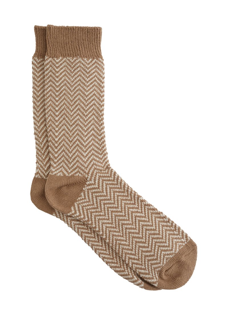 Brune sokker med fiskebensmønster, ribbede manchetter og blød tekstur. Designet har hvide zigzag-linjer mod den brune baggrund.