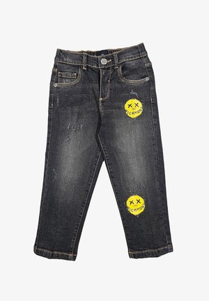 Jeans in denim nero con un design strappato, caratterizzati da toppe a forma di faccina sorridente gialla con testo. Stile classico a cinque tasche, vestibilità standard.