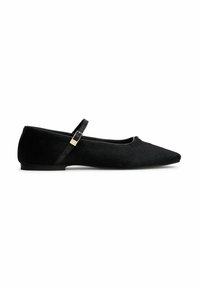Zapato plano negro con puntera puntiaguda, una delgada correa para el tobillo y hebilla dorada, con un material superior suave y texturizado.