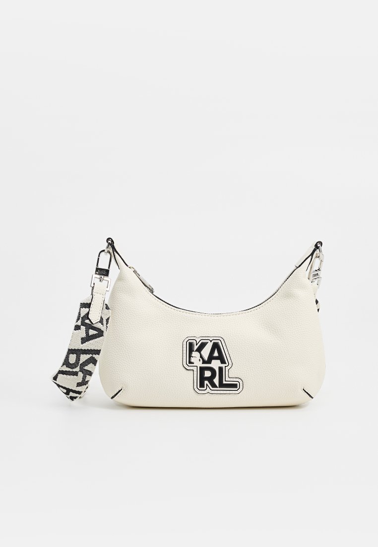 Petit sac à main en cuir texturé blanc avec un patch logo "KARL" noir et blanc et une bandoulière en tissu de marque détachable noir et blanc.