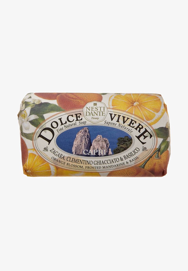 Natural soap bar with orange and floral design. Label features "Dolce Vivere Capri" with images of fruit and herbs. Wrapped in colorful paper.