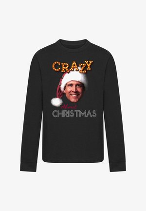 Schwarzes langärmeliges Shirt mit einem lächelnden Mann, der eine Weihnachtsmannmütze trägt, und dem Schriftzug „Crazy About Christmas“ in festlichen Schriftarten.