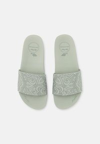 Light green slide sandals with a textured strap featuring an intricate paisley pattern. Soft material and flat sole for comfort.