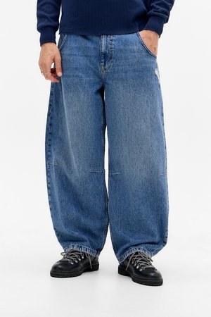 Wide-leg, light blue denim jeans, featuring a relaxed fit and subtle distressing on the front. Material is soft with a classic wash.