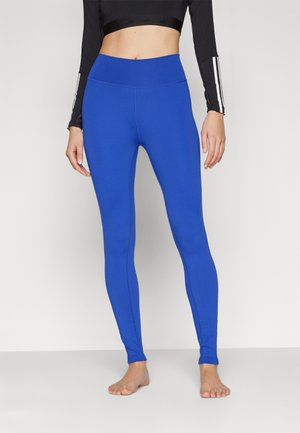 Blå högmidjade leggings gjorda av stretchigt material med en slät textur, som har en åtsittande design och sömlösa benkonturer.