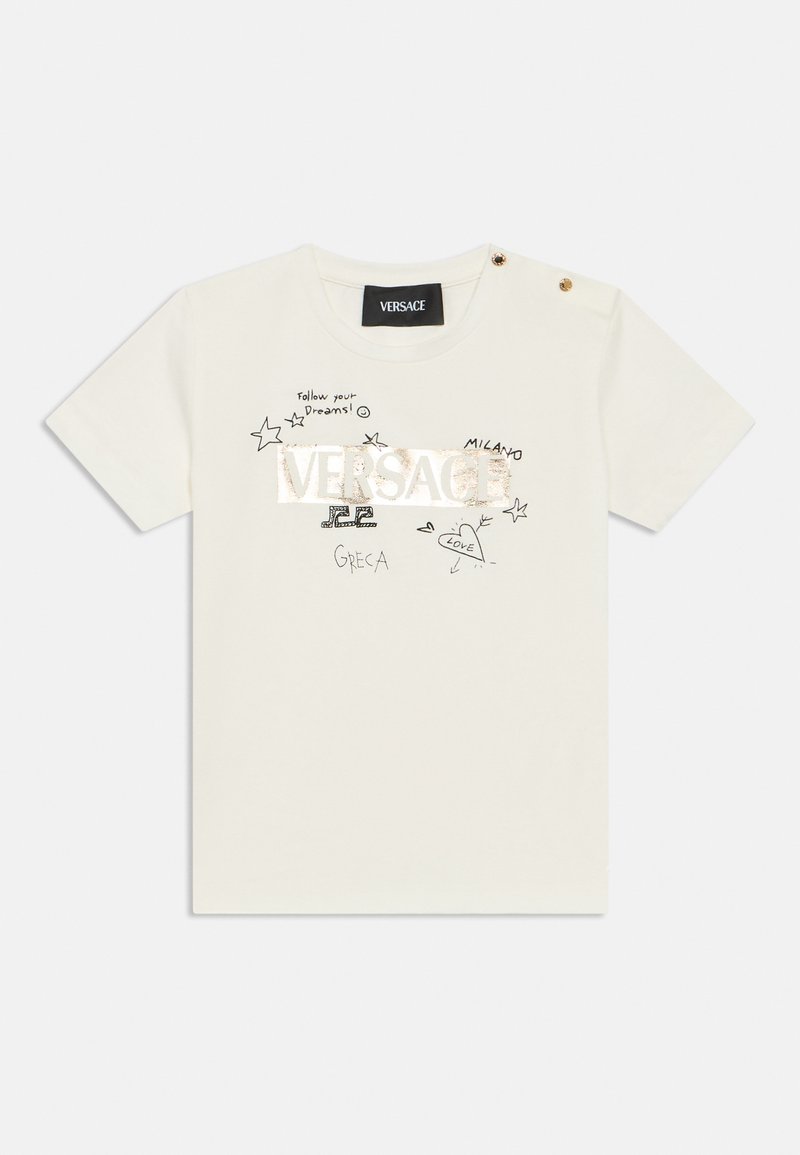 Μπεζ βαμβακερό T-shirt με έντονο μεταλλικό λογότυπο «VERSACE», χειροποίητα σχέδια και χρυσά κουμπιά-διακοσμητικά στον ώμο.