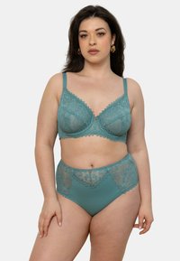 Ensemble de bralette en dentelle bleu canard et de culottes taille haute avec des bords festonnés et des accents de matériel décoratifs, présentant une base en tissu lisse.