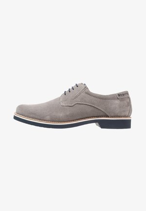 Chaussure habillée à lacets pour homme en daim gris avec semelle noire et bordure marron clair, talon bas, et marque Bugatti sur la languette du talon.