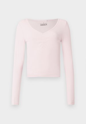 Hele roosa, pikematega varrukatega soonikkoes pluus V-kaelusega ja peene voltimisega esiosa keskel.