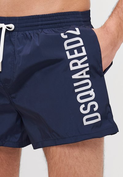 Tumed ujumispüksid kerge kangaga, külgedel valge vertikaalne logo, elastne vöökoht ja nöör.