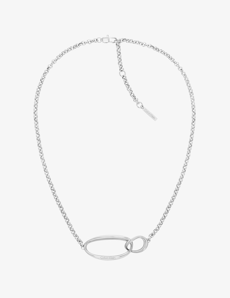 Silver chain necklace featuring an oval link detail, polished texture, and a small tag with branding. Designed with a lobster clasp closure.