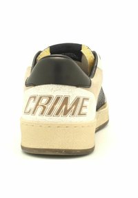 Sneaker con una toma beige e bianca testurizzata, dettagli neri e un logo "CRIME" in evidenza sul tallone. Suola piatta in gomma.