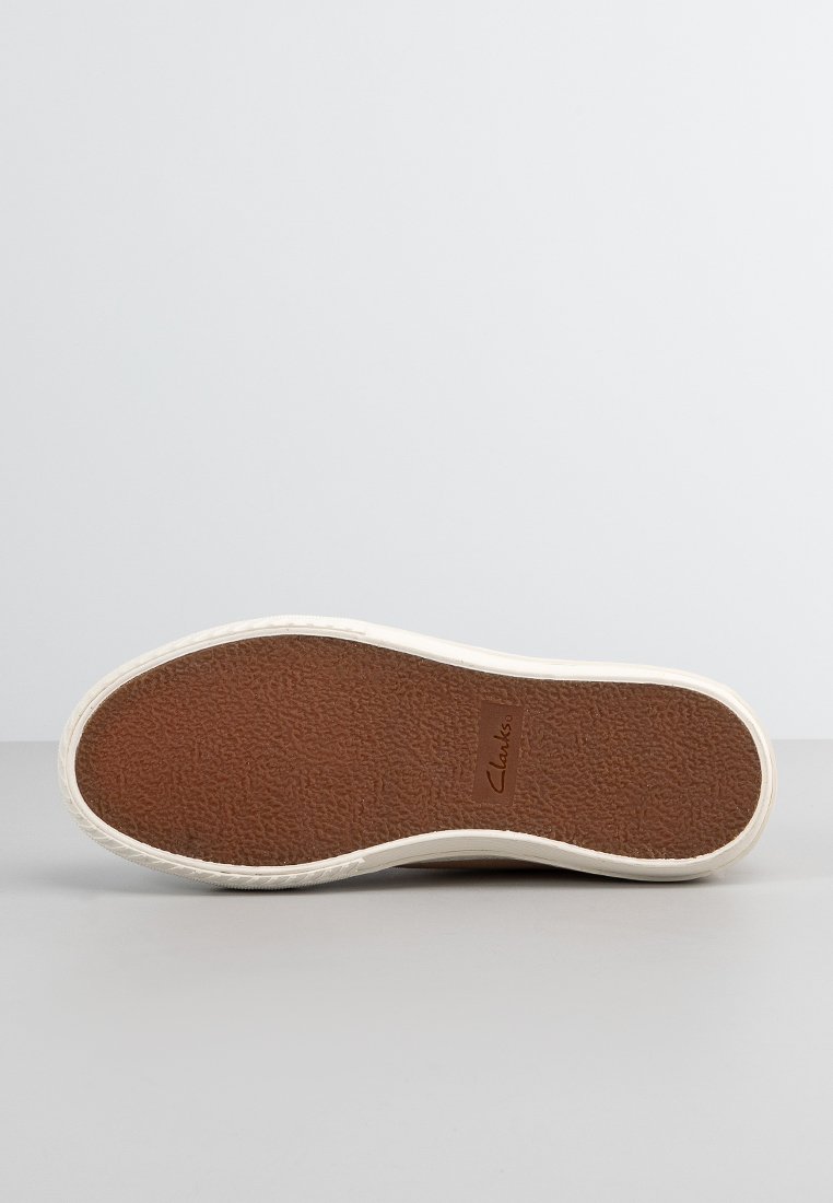 Suela de sneaker blanca con un fondo de goma marrón texturizada, que presenta el logo de "Clarks" en un color beige claro. Diseño plano para mayor comodidad.