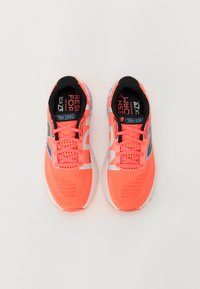 Bright neon orange running shoes with mesh upper, black interior, reflective accents, and textured soles. Features logo and laces.