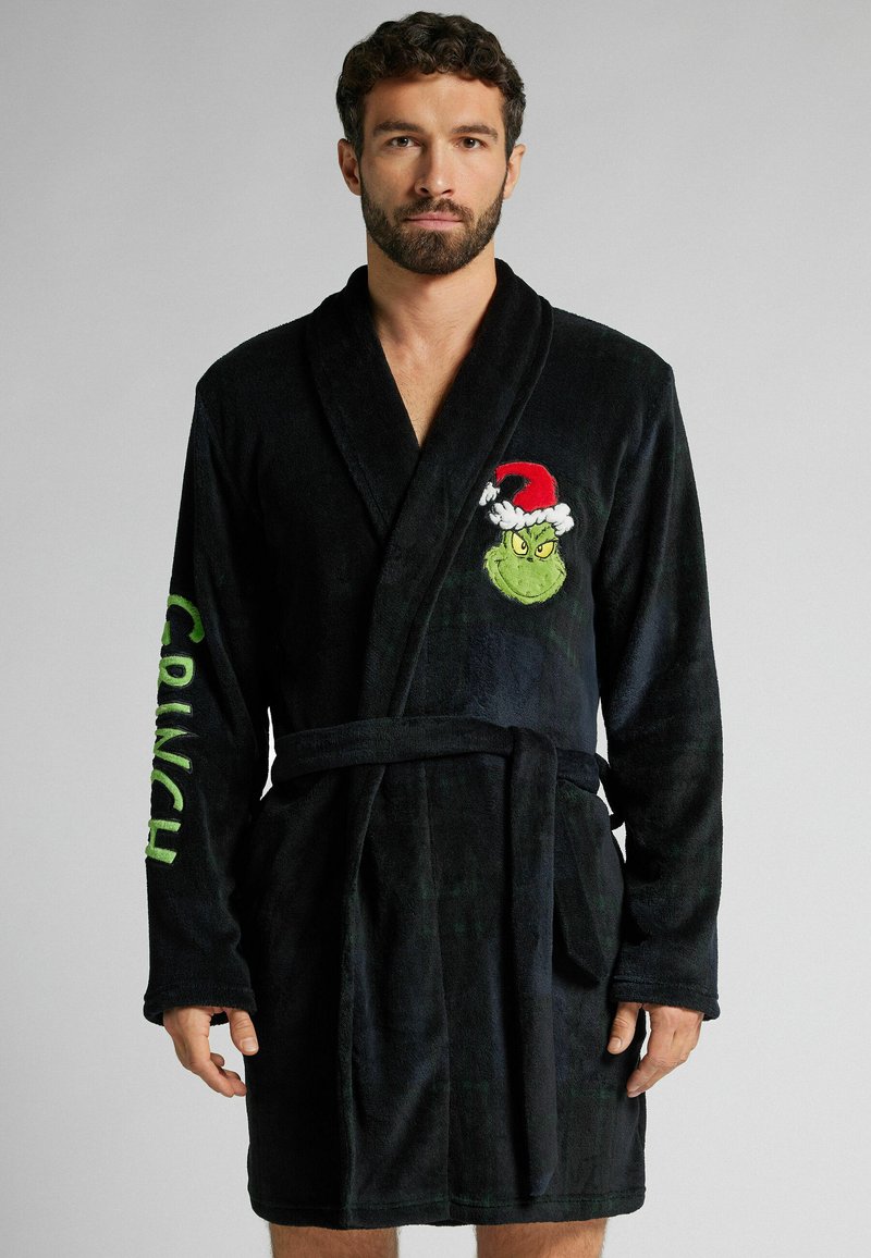 Czarny szlafrok z polaru z haftowanym Grinchem w czapce Mikołaja na lewej piersi oraz napisem "CRUNCH" w zielonym kolorze na prawej rękawie.