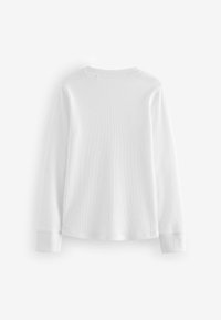 Chemise blanche à manches longues en texture côtelée avec un col rond. Les poignets sont ajustés et le dos n'a pas d'éléments de design. Style simple et minimaliste.