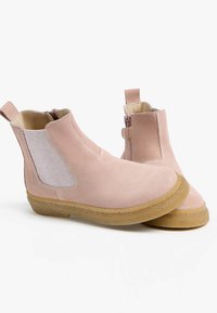 Stivaletti alla caviglia in suede rosa con pannelli laterali elastici, punta arrotondata e suola in gomma testurizzata. Presenta un cinturino e una chiusura con zip su un lato.