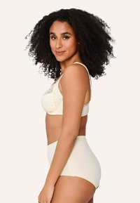 Grudnjak od čipke boje kreme s podesivim naramenicama, s cvjetnim uzorkom na košaricama; visokog struka odgovarajuće gaćice u glatkoj završnoj obradi.