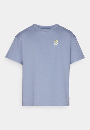 T-shirt en coton bleu clair avec des manches courtes et un col rond. Présente un petit graphique floral jaune et vert sur la poitrine gauche.