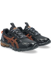 Scarpe sportive nere con accenti arancioni, tomaia in rete testurizzata, chiusura con lacci e suola imbottita con tacco in gomma traslucida.