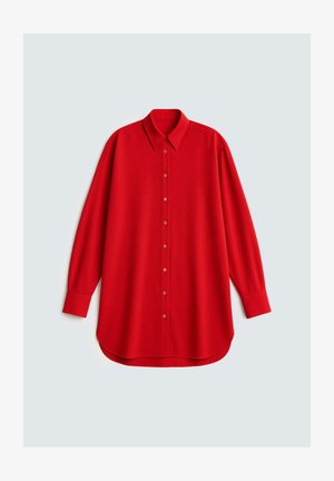 Μακρυμάνικο κόκκινο πουκάμισο με κουμπιά, με μυτερό γιακά και καμπυλωτό τελείωμα, παρουσιάζεται σε ανοιχτό γκρι φόντο.