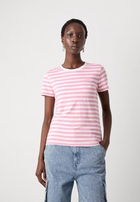Rutet kortermet t-skjorte i rosa og hvit bomull, rund hals, med en liten logo øverst til venstre, iført denim cargo-bukser.