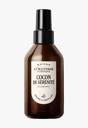 Brun sprayflaske med L'Occitane Cocon de Sérénité pudemist med sort låg og hvid etiket på fransk og engelsk.