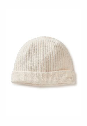 Bonnet crème côtelé en matériau doux, avec un revers roulé et un petit patch logo sur le côté.