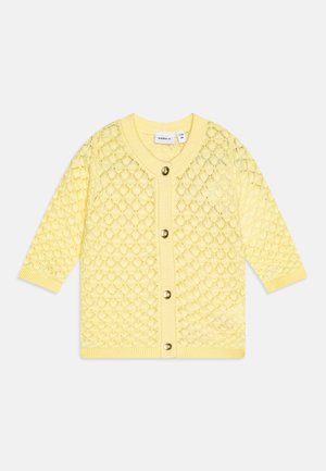 Gul strikket babycardigan med diamantmønster, lange ærmer, ribstrikkede manchetter og fire guldfarvede knapper foran.