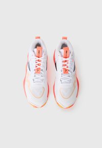 Pair of white athletic shoes with coral accents, black logos, and mesh details, viewed from above on a white background.