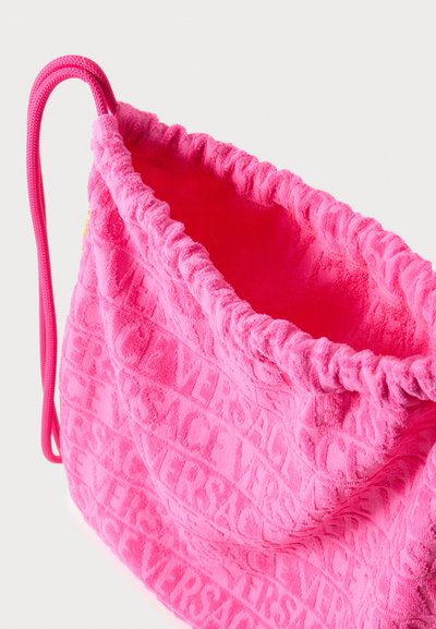 Ružičasta torba od frotira s uzorkom u reljefu "VERSACE", skupljenim vrhom i podesivim ručkom od užeta. Meka tekstura i živahna boja.