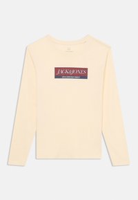 Langermet, kremfarget skjorte laget av bomull, med et rektangulært grafisk motiv med "JACK & JONES" i fet rød og marineblå tekst.