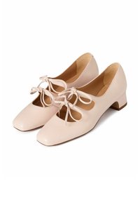 Scarpe di pelle rosa con punta quadrata e tacco a blocco piccolo, caratterizzate da dettagli a taglio e fiocchetti sulla parte anteriore. Texture liscia.