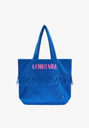 Sac cabas bleu avec longues anses, détail à franges et texte rose « LA DOLCE VITA » sur la partie avant haute.