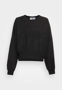 Sweatshirt noir avec un motif texturé de crocodile, col rond et manches fuselées avec des poignets élastiques. Conception cropped au niveau de la taille.