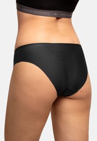 Intimo nero con una texture liscia e un design a vita bassa. Presenta una cintura grigia con il logo "DANISH ENDURANCE". Vista posteriore mostrata.