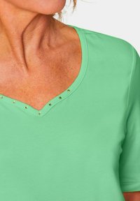 GOLDNER MIT CHARMANTEM AUSSCHNITT - T-shirt print - light green