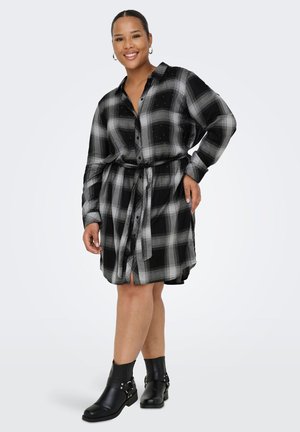 Black and gray plaid shirt dress with buttons, long sleeves, a belt, and side slits, paired with black ankle boots featuring silver hardware.
