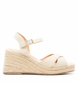 Sandalo zeppa beige con platforma in juta intrecciata, cinturini incrociati in tessuto e cinturino regolabile alla caviglia con fibbia.