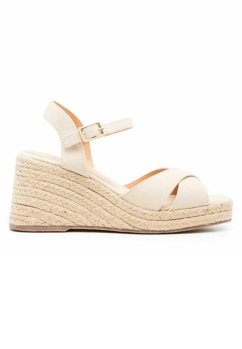 Sandale compensée beige avec plateforme en jute tressée, brides croisées en tissu et bride de cheville ajustable avec boucle.